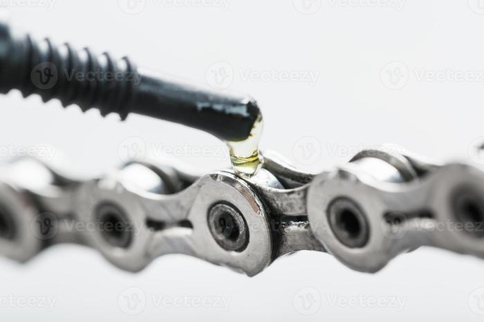 Lubricating a bicycle chain with a drop of oil close-up on an isolated ... Lube a Bicycle Chain